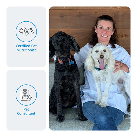 Woman with two dogs, one black and one white, in a pet consulting or nutritionist setting.